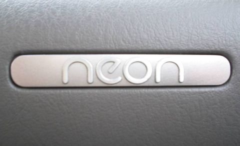 1995 Plymouth Neon - A close-up view of the 'neon' emblem, likely from a vehicle's interior trim.