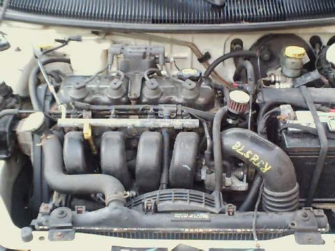 1995 Plymouth Neon - The engine bay of a car is shown, with various hoses, wires, and components visible.