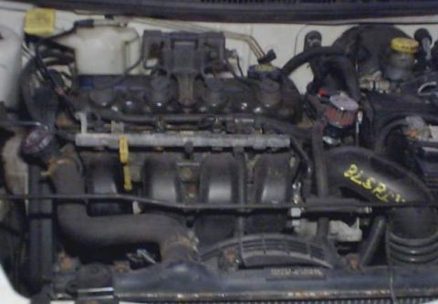 1995 Plymouth Neon - Close-up view of a vehicle's engine bay, showing various components and hoses. Text 'BLSP' is visible on a black hose.