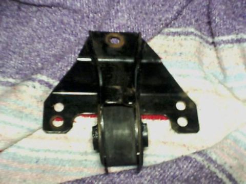 1995 Plymouth Neon - A black metal engine mount bracket with a rubber isolator is shown against a patterned cloth.