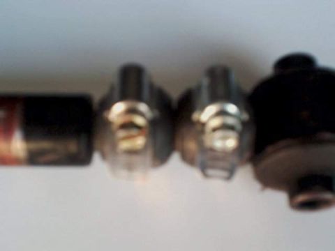 1995 Plymouth Neon - Four automotive light bulbs are lined up, showing their metal bases and filaments.