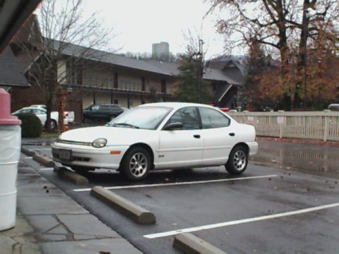 1995 Plymouth Neon - A white 1995 Plymouth Neon is parked in a lot on an overcast day.