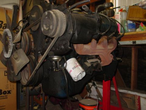 1978 Ford Bronco - An engine assembly is shown, mounted on a red stand with various components attached.