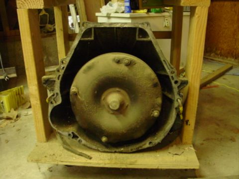 1978 Ford Bronco - Close-up of a dusty automatic transmission torque converter supported by a wooden frame.
