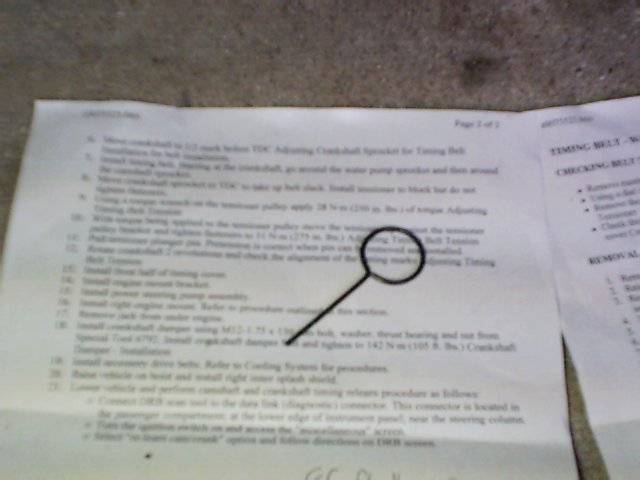 Paper with numbered steps for car repair, including a magnifying glass over a section