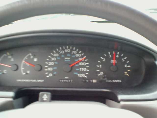 Dashboard gauges of a 1995 Plymouth Neon, showing speedometer, tachometer, fuel, and temperature