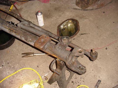 1992 Ford Bronco - Disassembled vehicle steering and suspension components are laid out on a workshop floor.