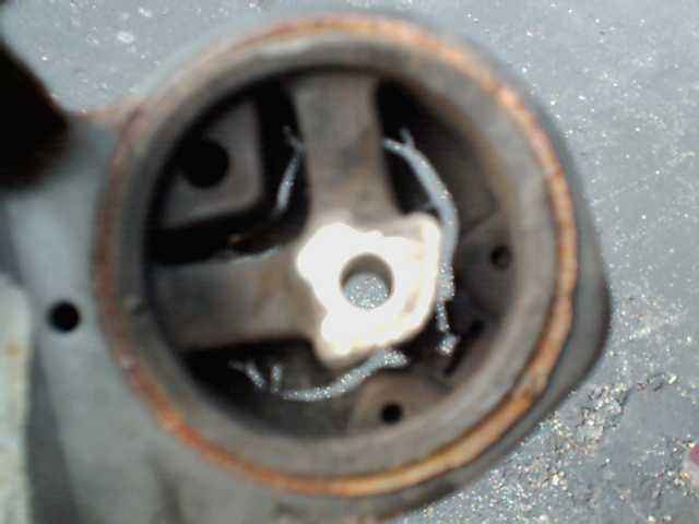 Close-up of a worn engine mount with visible metal and rubber components