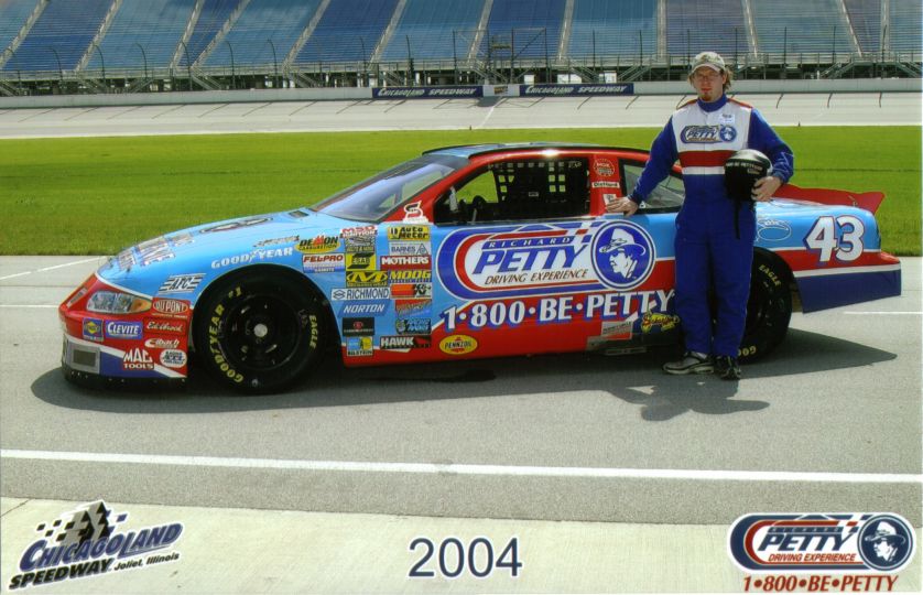 Richard Petty Driving Experience stock car with driver standing next to it. Car has number 43 and many sponsor decals