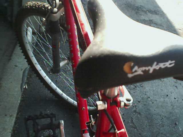 close-up of a red bicycle seat and front wheel
