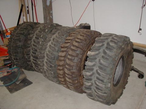 1988 Ford Bronco - A collection of tires are lined up indoors, ready for off-road adventures.