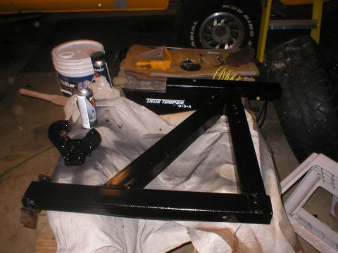 1978 Ford Bronco - Trailer hitch receiver and parts laid out for painting, with tools and supplies visible.