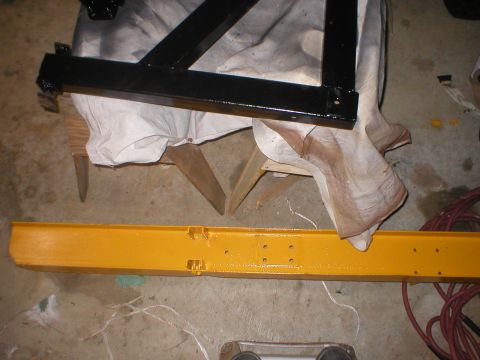 1978 Ford Bronco - Two painted metal components are laid out on a concrete floor, possibly awaiting assembly or installation.