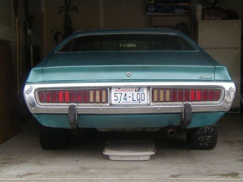 1993 Ford Bronco - Rear view of a teal 1971 Dodge Charger, its distinctive horizontal taillights and chrome bumper.