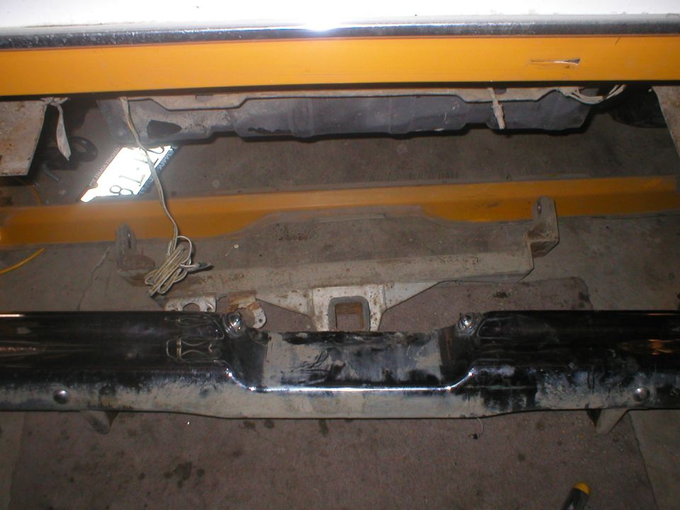 Rear bumper assembly with tow hitch receiver and wiring. Yellow support beams visible above