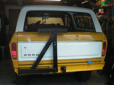 1978 Ford Bronco - Rear view of a yellow and white 1978 Ford Bronco, equipped with a swing-away spare tire carrier.