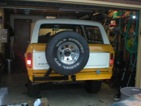 1978 Ford Bronco - The rear of a classic Ford Bronco is shown, parked inside a garage with the door open.