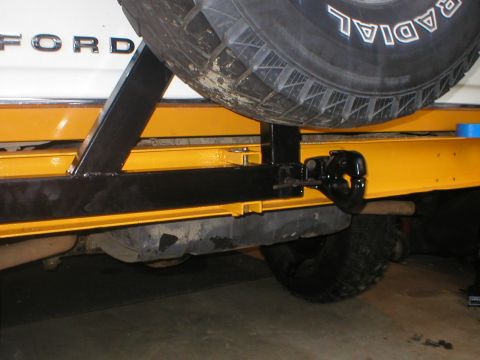 1978 Ford Bronco - Rear view of a white 1978 Ford Bronco showing the bumper, spare tire mount, and tow hitch.