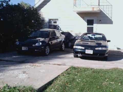 1994 Eagle Talon - Two cars are parked in a driveway in front of a house. One is a 1995 Dodge Neon.