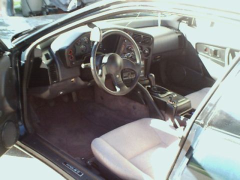 1994 Eagle Talon - The interior of a car is visible, including the dashboard, steering wheel, gear shifter, and passenger seat.