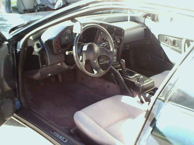 Interior shot of a car, showing the dashboard, steering wheel, and seats