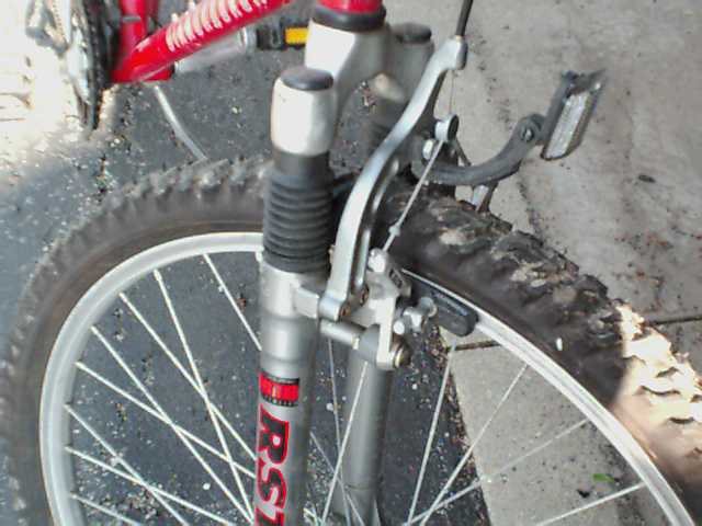 Close-up of bicycle front fork with 'RST' logo and wheel