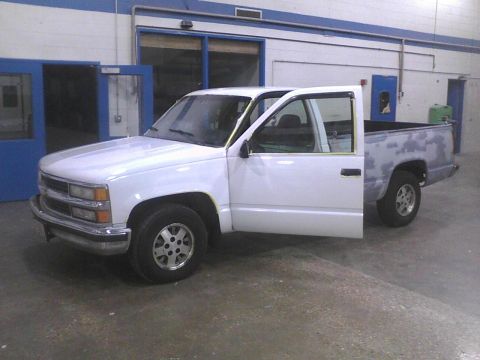 2003 Ford Crown Victoria - This white pickup truck is shown from the front three-quarter angle on the driver's side, with the rear bed area covered in primer.