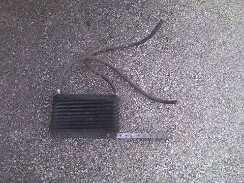 2003 Ford Crown Victoria - An aftermarket oil cooler with hoses is shown on a gravelly surface.
