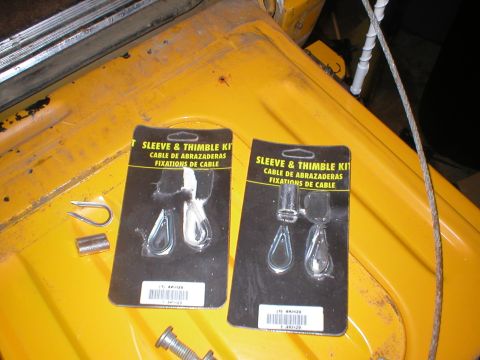 1978 Ford Bronco - Two packaged sleeve and thimble kits for cable repair are shown on a yellow surface, along with loose hardware.