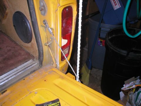 1978 Ford Bronco - Detail of a tailgate cable and taillight assembly, likely from a vintage vehicle.