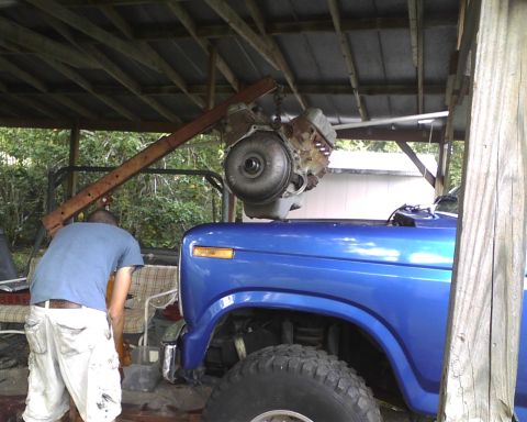 1985 Ford Bronco - A blue 1985 Ford Bronco is shown with its engine being removed by a hoist.