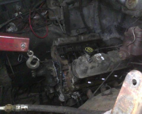 1985 Ford Bronco - Engine bay detail with engine hoist hook attached. Supermotors.net logo is visible.
