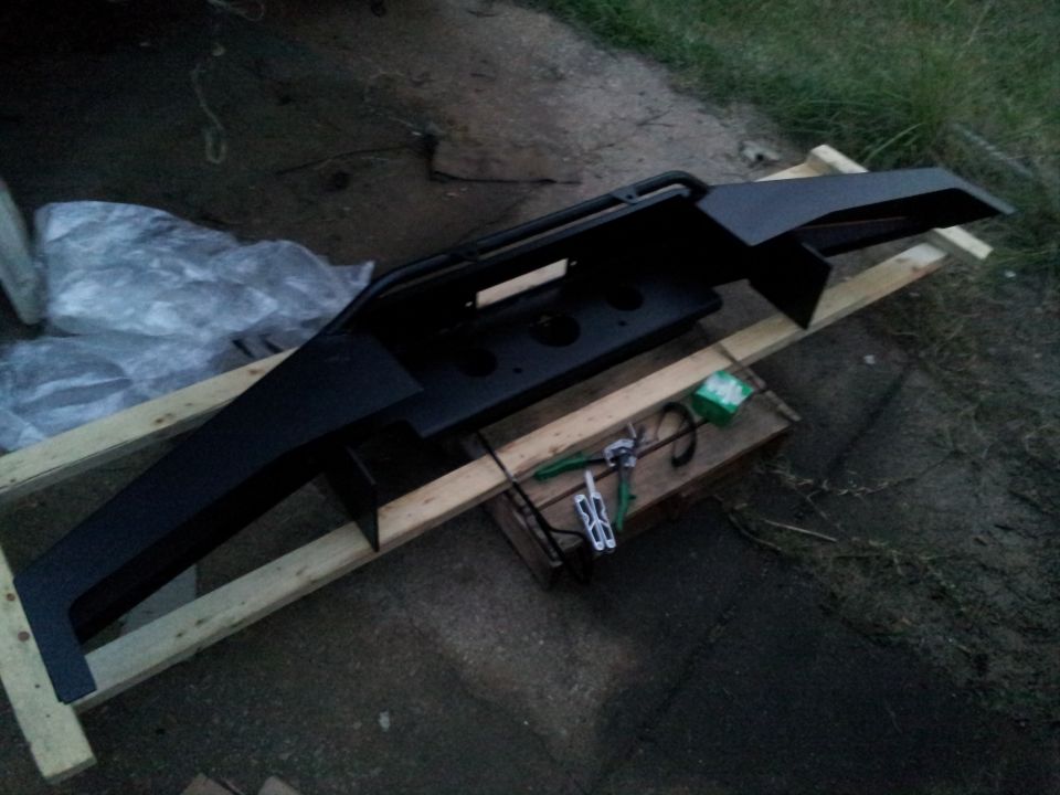 aftermarket front bumper with winch mount, resting on wood supports