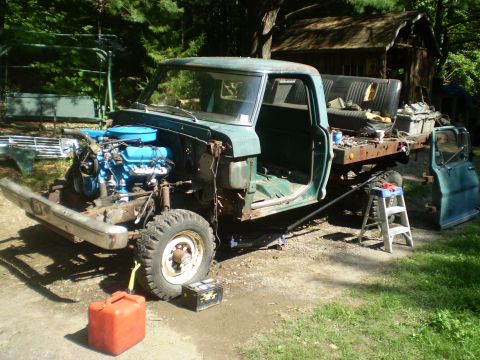 1979 Ford Bronco - Pickup truck undergoing restoration with engine removed and parts scattered around.