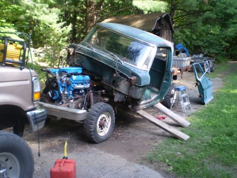 1979 Ford Bronco - Pickup truck cab undergoing work, with engine removed and supported by ramps.