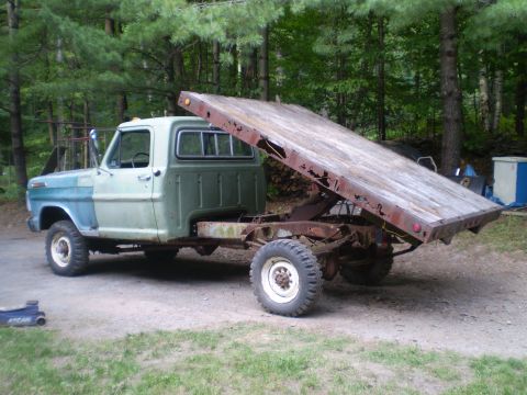1979 Ford Bronco - This Ford F-Series truck has a flatbed that is tilted upwards, showing its rusty metal frame.