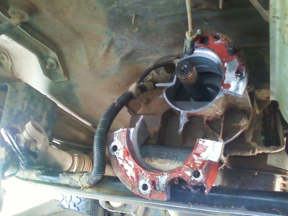 Damaged red and silver transmission housing with exposed driveshaft splines