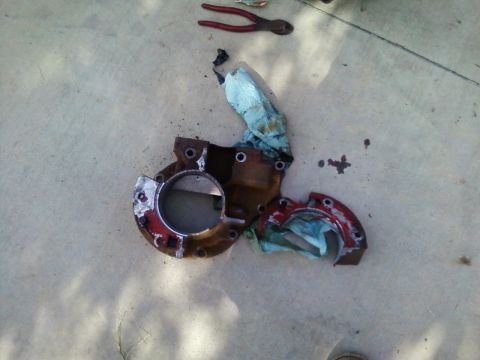 1996 Ford Bronco - A cracked transmission extension housing, likely from a Ford Bronco, lies on a concrete surface.