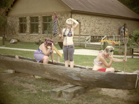 1989 Ford Bronco - People pose in a dugout canoe outside a stone building.