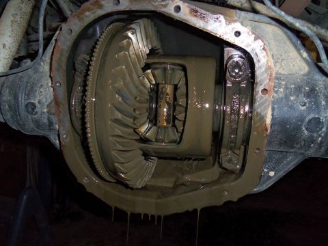 1989 Ford Bronco - Close-up view of a vehicle's differential, showing gears covered in mud and fluid.