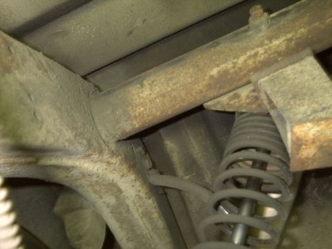 1964 Ford Galaxie - The underside of a vehicle reveals a rusty frame and suspension components, with no clear year identification.