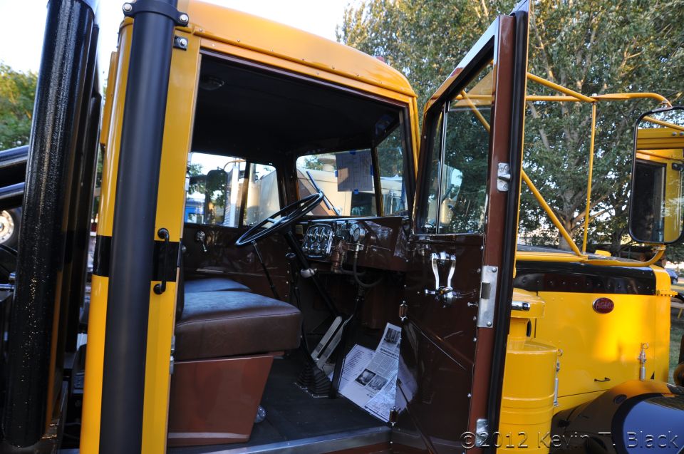 Yellow and brown truck interior with open door, showing dashboard and seat