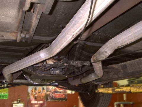 1964 Ford Galaxie - Underside view of a 1964 Ford Galaxie, highlighting its dual exhaust system and drivetrain components.