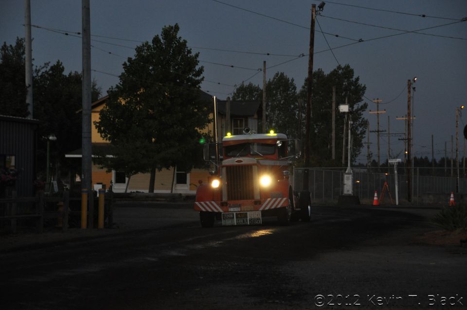 Orange and white truck with headlights on, front view