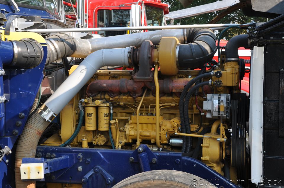 close-up of a large diesel engine with yellow and blue components, large pipes, and filters labeled CAT