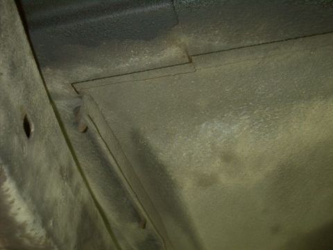 1964 Ford Galaxie - The undercarriage of a vehicle is visible, with textured metal and some signs of wear.