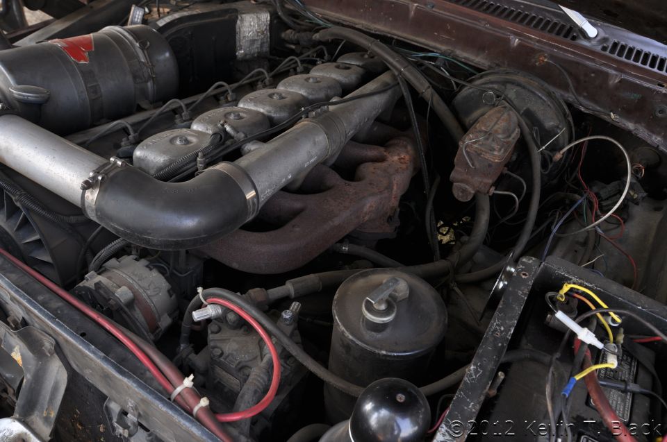 close-up of a diesel engine with exhaust manifold, intake pipes, and air filter housing