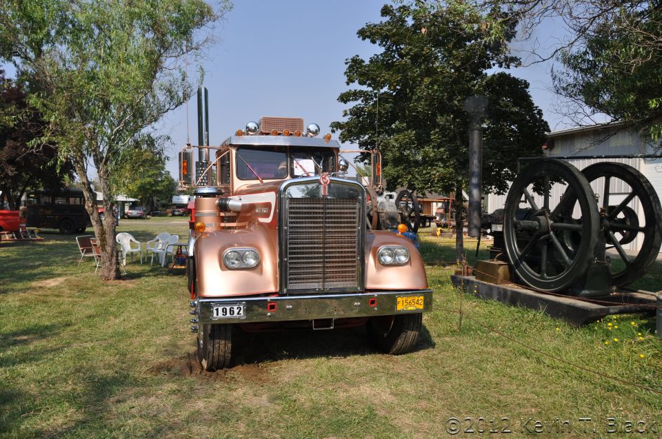 Copper semi-truck with chrome grille and dual stacks, parked on grass