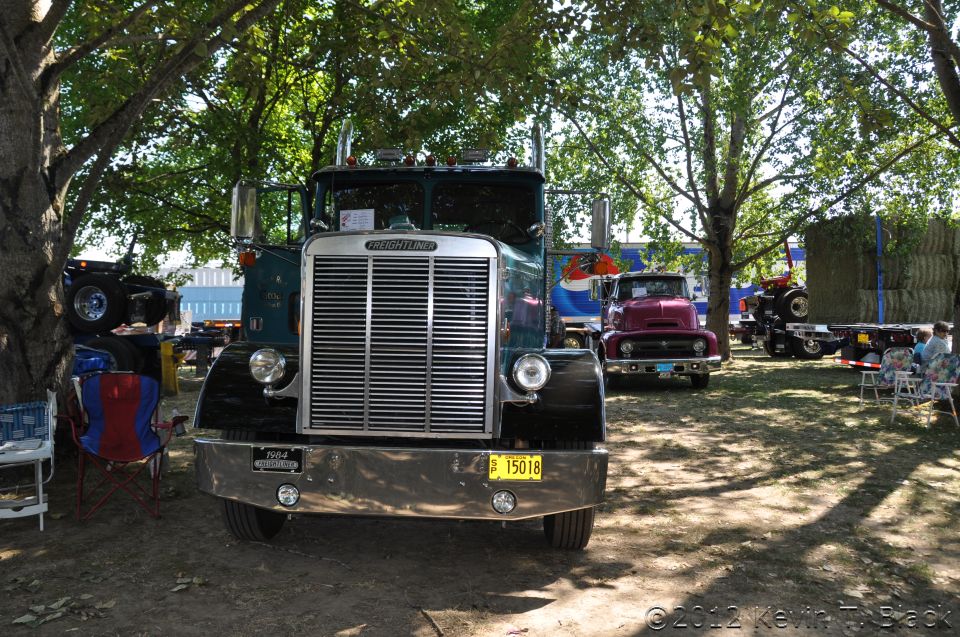 Green Freightliner truck with chrome grille and bumper, 1964 badge