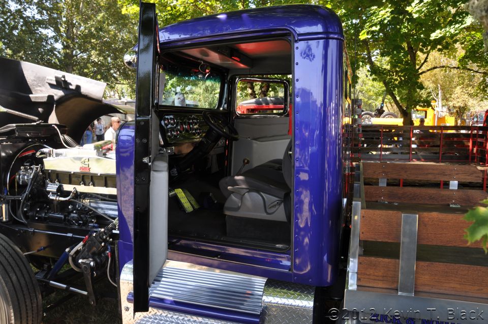 Purple truck cab interior with exposed engine and wooden flatbed
